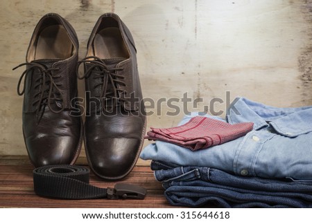 still life with men\'s outfit on wooden table