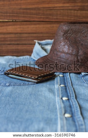Leather hat and wallet on denim shirt