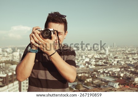 young boy tourist taking photos on the top of deserted building in Bangkok at Thailand
