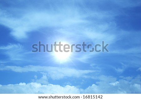 the burning-hot sun on background of blue sky and clouds