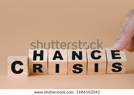 Hand flipping wooden cubes for change wording" Crisis "  to " Chance".  Mindset is important for human development.