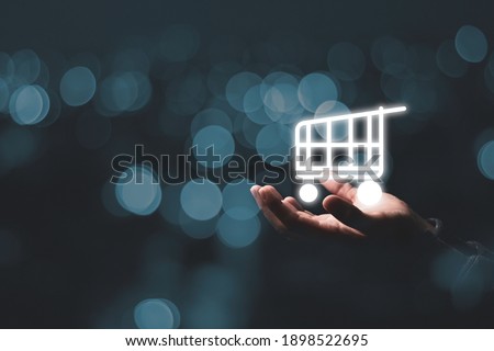 Business holding virtual shopping cart trolley with blue bokeh , Online shopping concept. Stockfoto © 