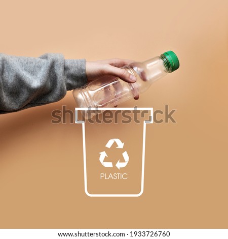 A man throws a plastic bottle into a dumpster .Sorting and recycling of garbage