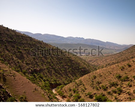 Deep canyon with the river channel on the background of sky