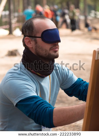 Man blindfolded hands working on a blurred background