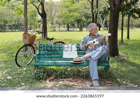 Similar – Image, Stock Photo Cheerful man playing ukulele guitar