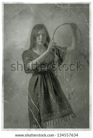 Indian squaw girl in traditional Indian wear and dream catcher posing to the camera. Vintage photo 1800s toned image sepia with frame