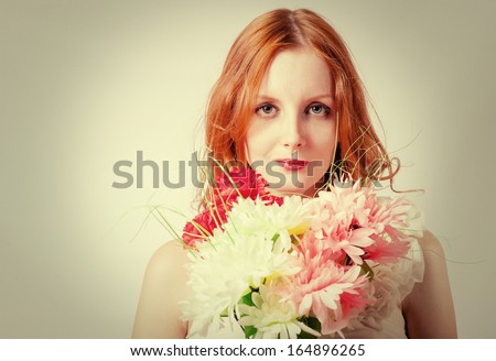 Beautiful redhead women looking at camera with flowers studio head and shoulders  shot