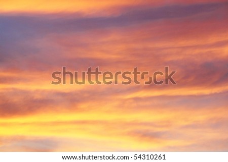 Sun in the orange sky covered with clouds
