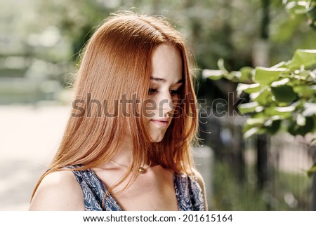 Young cute red haired women outdoors in calm state of the mind