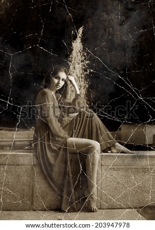 Retro stylized photo of young women in long dress sitting near fountain.