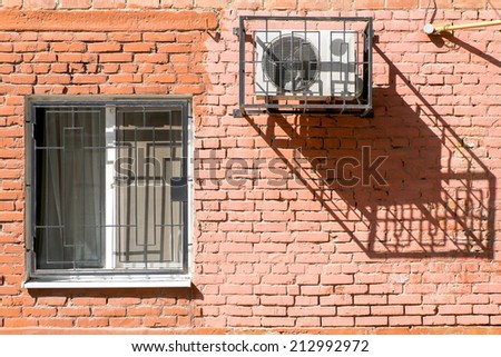 Window and air conditioner on a brick wall.