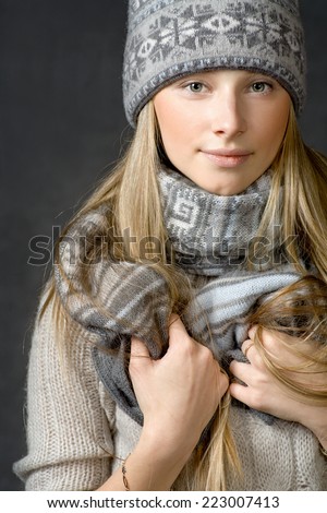 Calm woman in a wool cap. Young pretty woman portrait in studio. Beautiful young woman relaxing in a winter wear front view, looking at camera