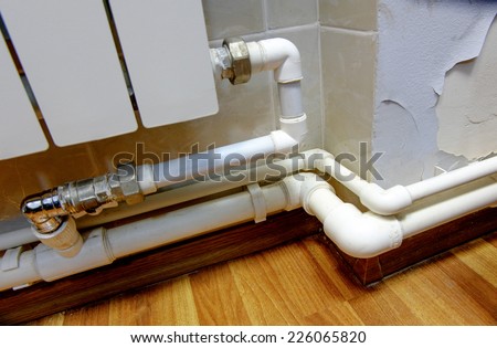 Fragment of the heater indoors and hot water pipes connected with a lot of copyspace