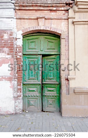 Old wooden door painted in green color in Russia