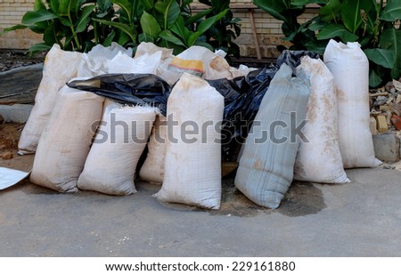 Set of many bags of cement on the ground. Transportation to the castomer.