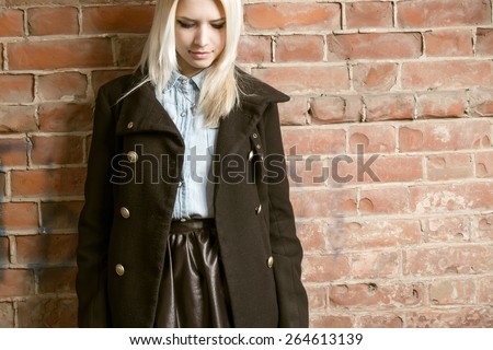Beautiful hipster woman wear vintage jacket. Toned in warm colors. Outdoors shot, lifestyle. Hipster girl posing against red brick wall. A lot of space for text