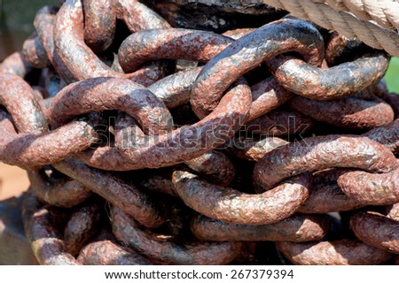 Rows of rusted chains. Heavy rusted metal chain. Big links of the chain covered with red rust with shadows and hotspots