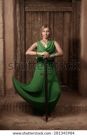 Women in long green dress with long sword