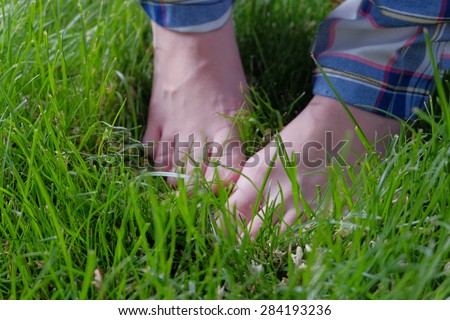 Feet in grass. Barefoot summer pleasure. Sexy cute legs of young women in fresh green grass. Very cute looking image. Freshness and tenderness. Copyspace for text on grass.
