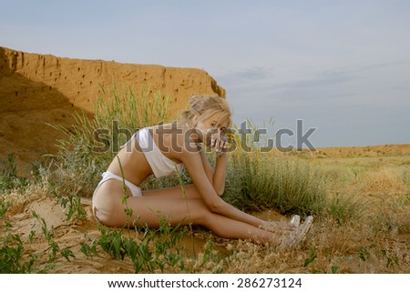 Women in desert. Female siting on desert sand