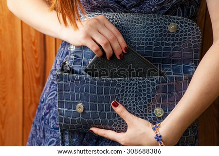 Women get out fashion thing from blue fashionable handbag.