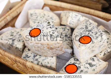 Blue cheese lying in a basket with blank price stickers on.