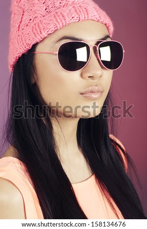 Teenage girl in woolly hat and sunglasses