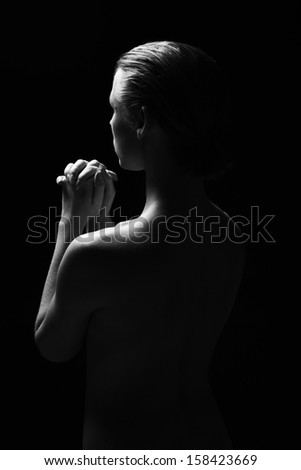 Naked woman showing emotions against a black background