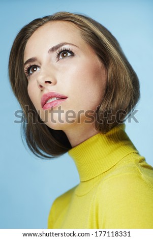 Portrait of young woman in yellow polo neck