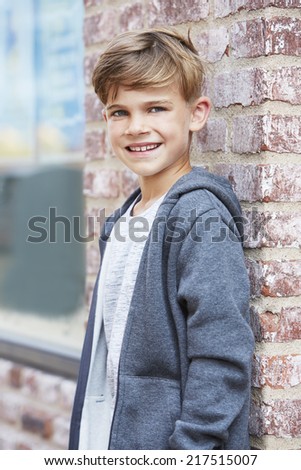 Young boy leaning against wall, portrait