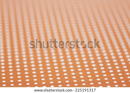 Close up of orange and white spotted textile