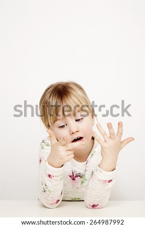 Blonde girl counting finger in studio