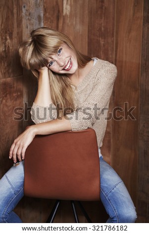 Gorgeous young woman on chair, smiling