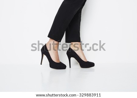 Low section of woman in black high heels