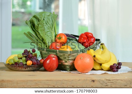 Fresh fruits and vegetables with wicker basket on table
