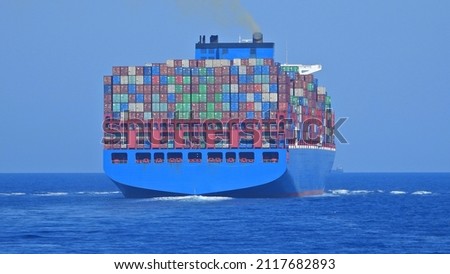 Zoom photo of huge container tanker ship carrying truck size colourful containers in deep blue open ocean sea ストックフォト © 
