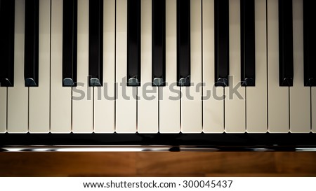 Top view of  a piano keyboard with wooden floor background in vintage looks.