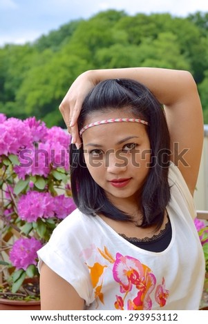 Asian woman wearing head band, flower and tree background
