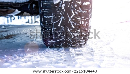 Driving car with winter tire wheel on snow road