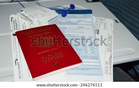 FLIGHT MOSCOW-LONDON - FEBRUARY 26: Russian passport for travel abroad, customs declaration, boarding pass and luggage tag on the table in the airplane from Moscow to London on February 26, 2014.