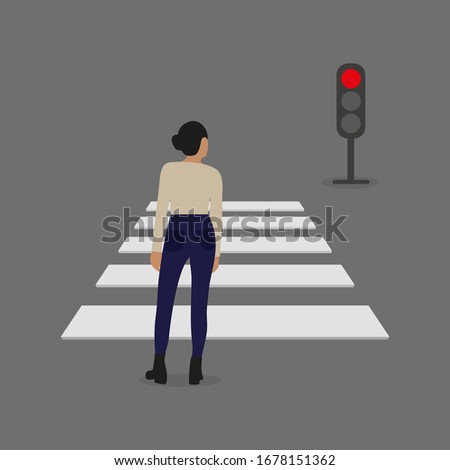 Female character stands in front of a pedestrian crossing and a traffic light with a red signal