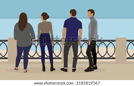 Four people stand on the embankment and look at the water