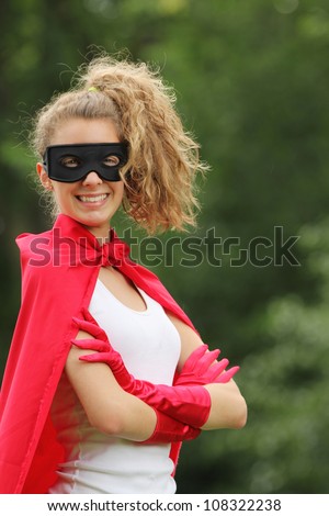 smiling blond and young woman with a mask and red super hero kit