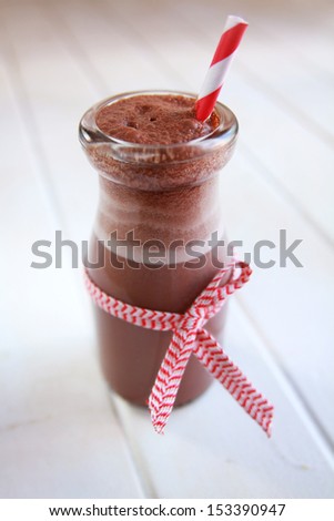 Chocolate milk in a bottle with red ribbon and red straw