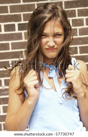 Angry teenager girl with hair in hand