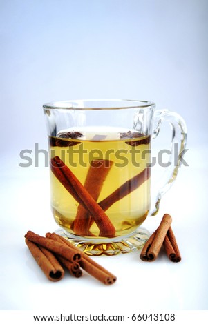 Apple juice with cinnamon stick in a big and clear cup