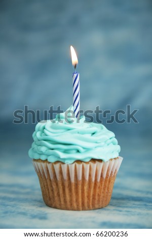 Blue birthday cake with candle on a blue background