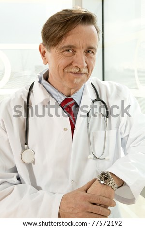 Confident doctor with white smock and stethoscope around the neck