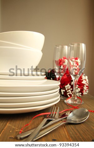 Plain white plates, bowls and glass of wine